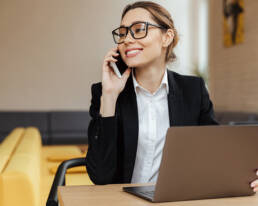 Cheerful business woman talking by mobile phone